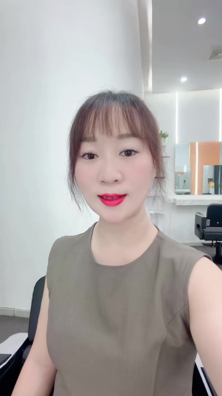 美发门店拍摄现场，工作人员正在为顾客做烫染造型，旁边立着门店活动海报
